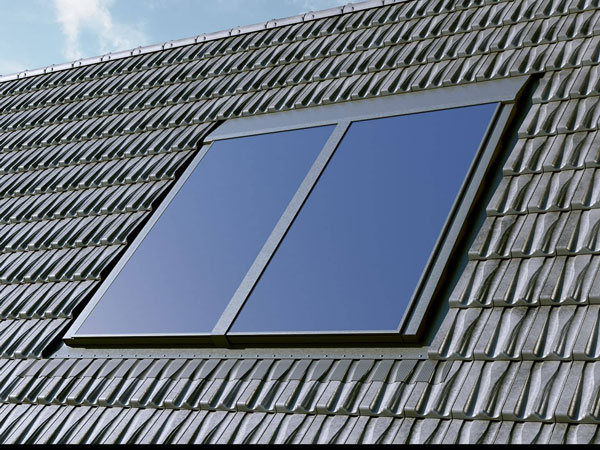 Zwei Solarkollektoren auf einem geneigten Hausdach mit Dachziegeln.