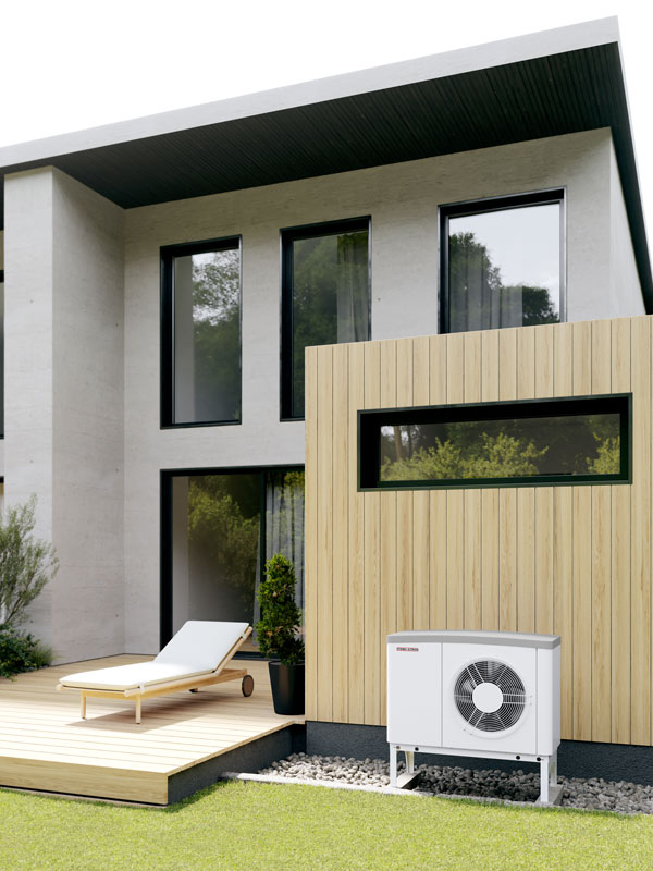 Weiße Wärmepumpe außen an einem modernen Haus mit Holzverkleidung und Terrasse.