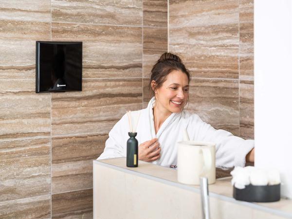 Frau im Badezimmer mit Limodor Abluftsystem an der Wand – frische Luft und modernes Design.
