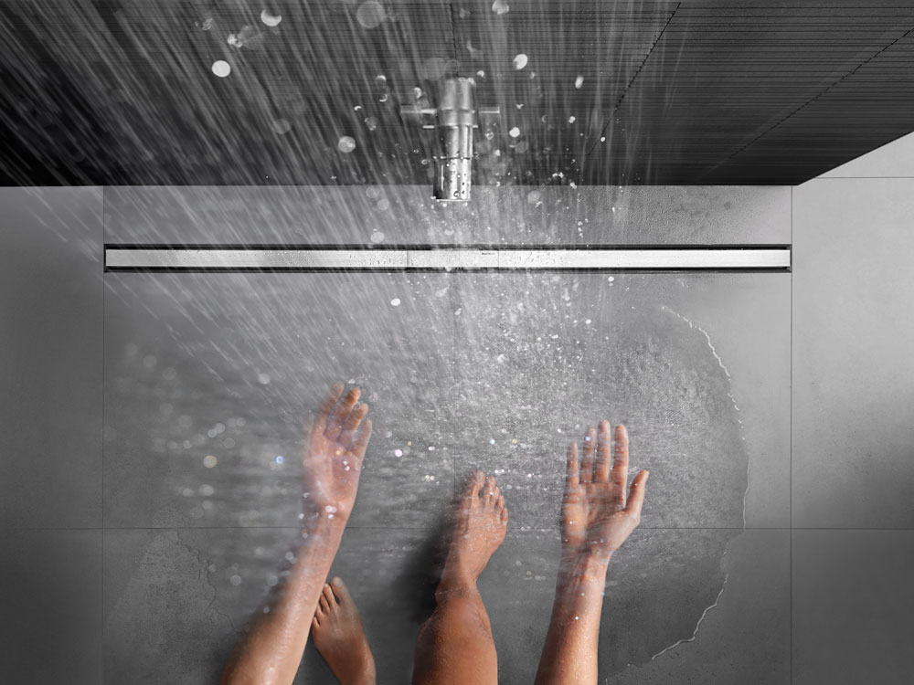 Wasser fließt in moderner bodenebener Dusche mit Geberit CleanLine Duschrinne.