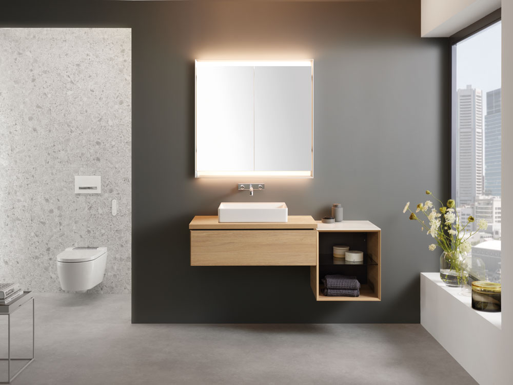 Modernes Badezimmer mit Geberit Sela Waschtisch, beleuchtetem Spiegelschrank und wandhängendem WC.